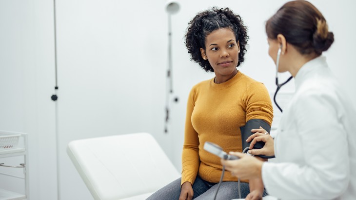 primary care service image of doctor taking blood pressure of patient at rome health hospital near rome ny