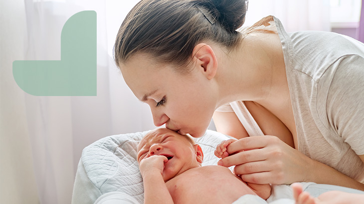 maternity care image of female mother kissing her newborn baby at rome health hospital near rome ny